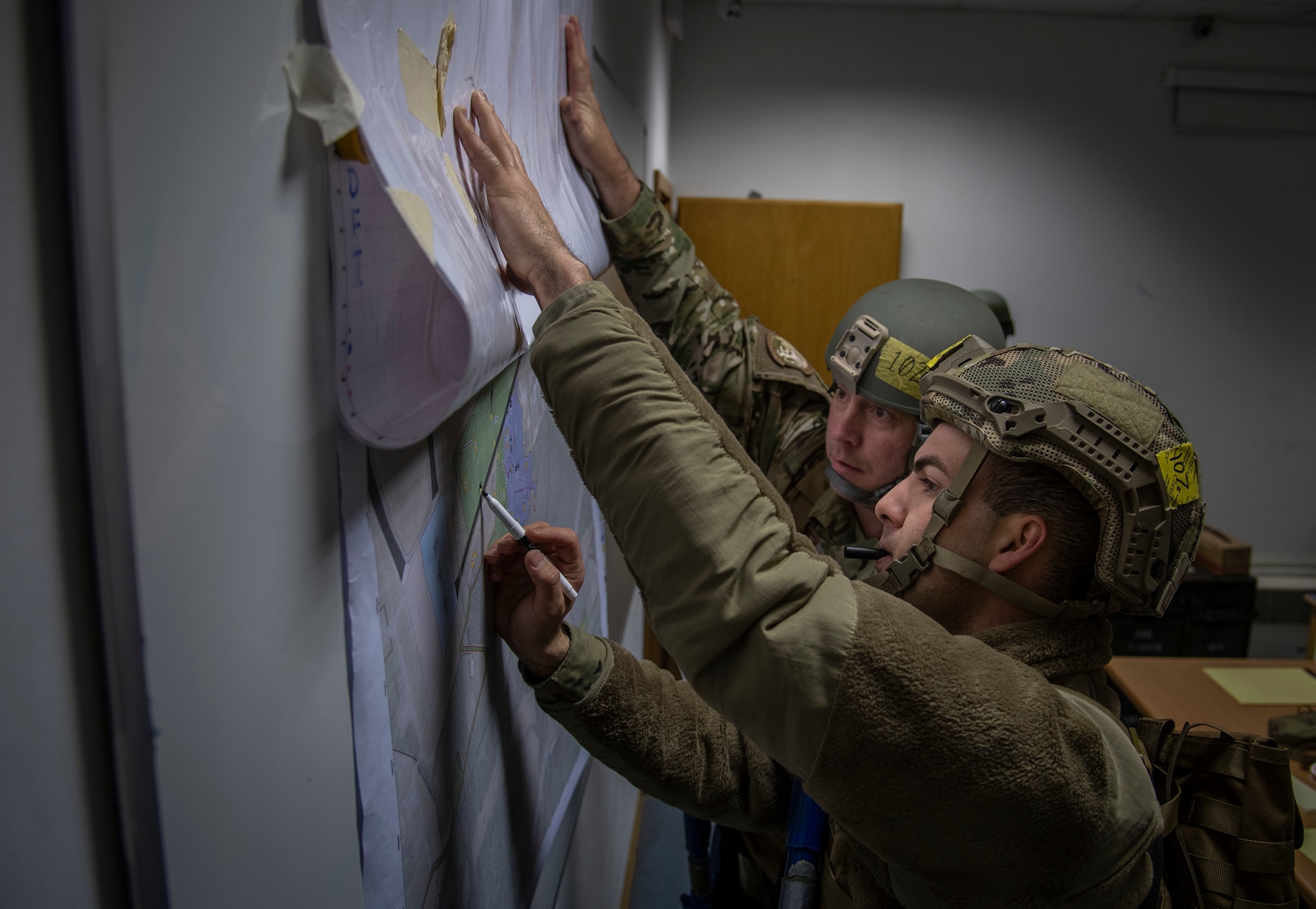 U.S. Air Force Airmen with the 435th Construction and Training Squadron look at a map on Ramstein Air Base, Germany during a Silver Flag training course, Nov. 17, 2021.