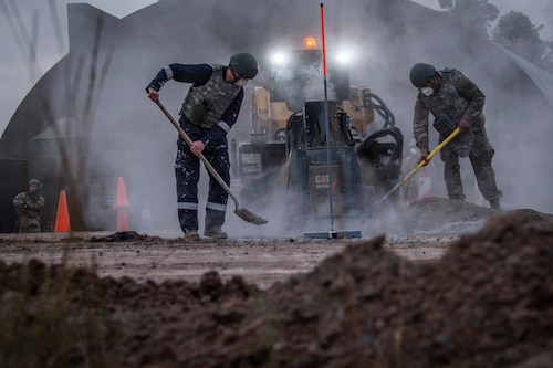 U.S. Air Force Airmen with the 435th Construction and Training Squadron pour concrete during rapid airfield damage recovery training at Ramstein Air Base, Germany during a Silver Flag training course, Nov. 18, 2021.