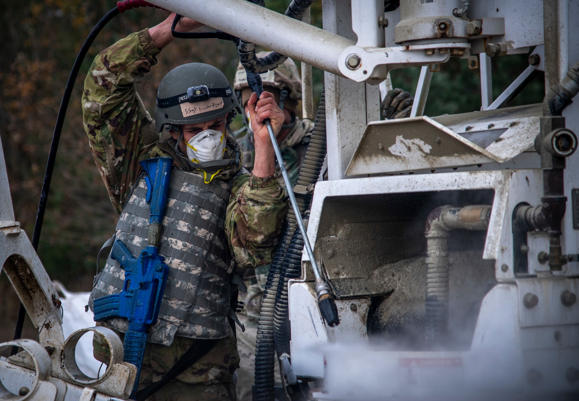 U.S. Air Force Staff Sgt. Nicolas Erjavesk, Portland Air National Guard Base, Ore. 142nd Civil Engineer Squadron heavy equipment operator, uses a power washer to clean equipment used to pour concrete between pours at Ramstein Air Base, Germany during a Silver Flag training course, Nov. 17, 2021.