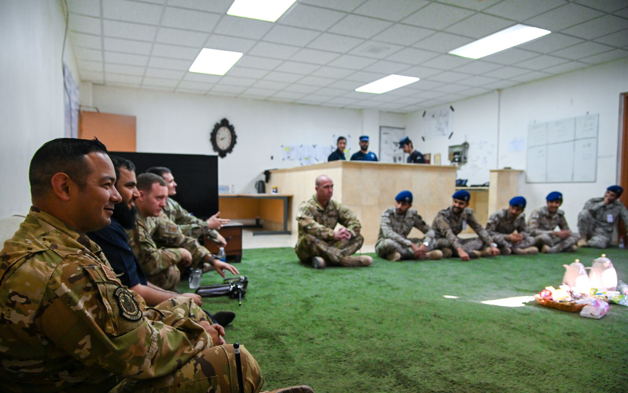 Airmen from the 378th Expeditionary Civil Engineer Squadron fire department share tea with service members from the Royal Saudi Air Force during an integrated training at Prince Sultan Air Base, Kingdom of Saudi Arabia, Nov. 24, 2021. The act of sharing tea is a staple of hospitality in Saudi culture and allows both teams the opportunity to bond in a more informal and welcoming environment. (U.S. Air Force photo by Staff Sgt. Christina Graves)