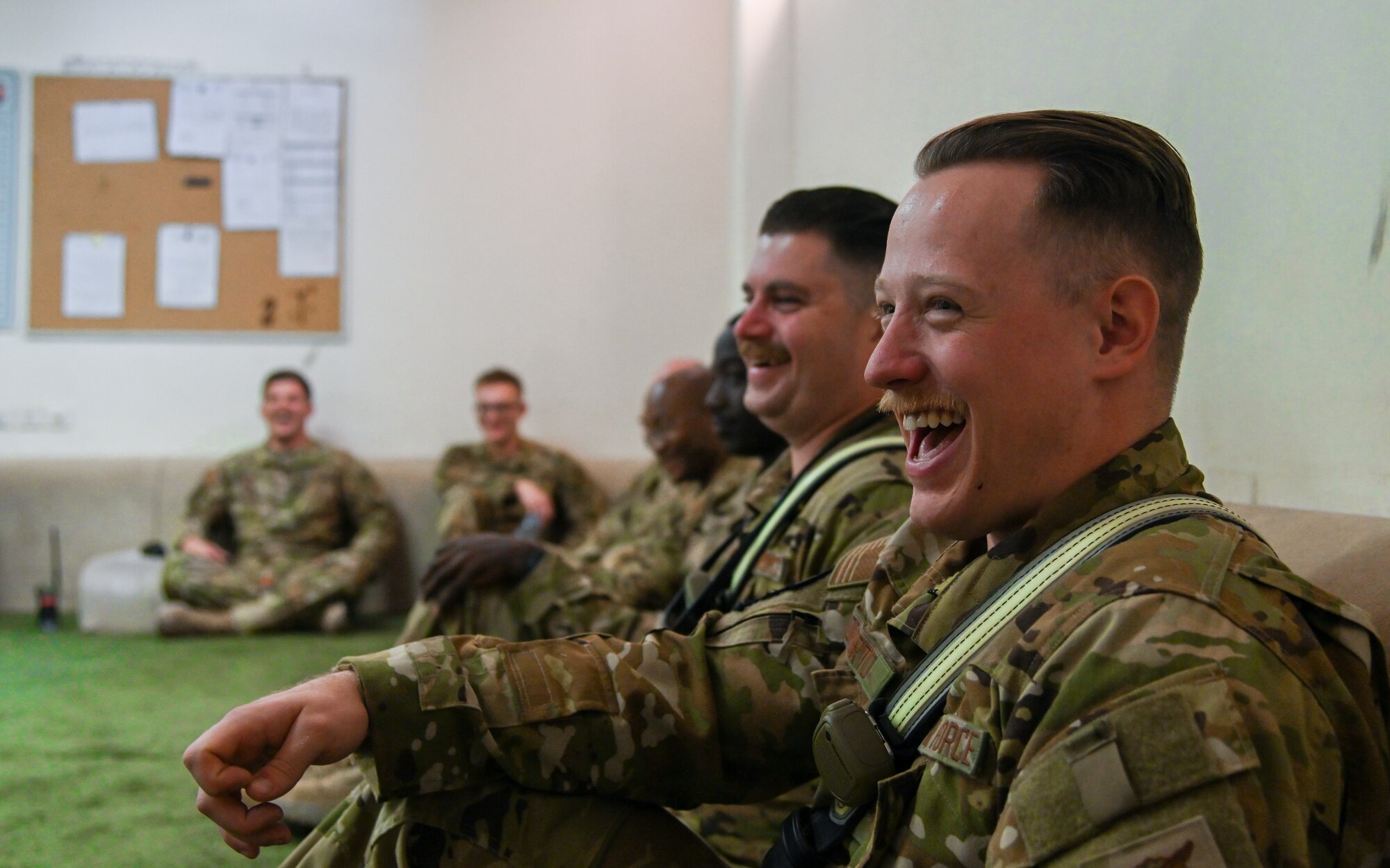 Airman 1st Class Tyler S. Loporto, 378th Expeditionary Civil Engineer Squadron fire fighter, laughs alongside members of his unit while sharing tea with service members from the Royal Saudi Air Force during an integrated training at Prince Sultan Air Base, Kingdom of Saudi Arabia, Nov. 24, 2021. The act of sharing tea is a staple of hospitality in Saudi culture and allows both teams the opportunity to bond in a more informal and welcoming environment. (U.S. Air Force photo by Staff Sgt. Christina Graves)