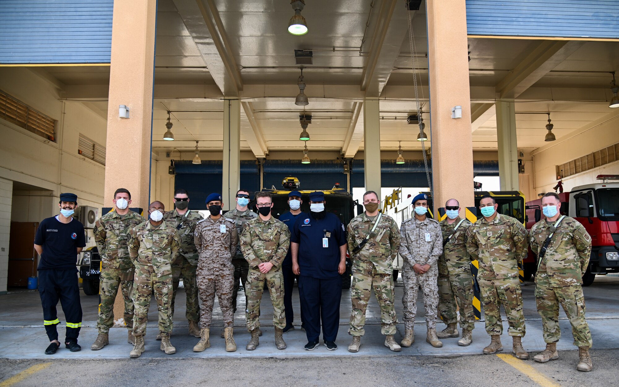 Airmen from the 378th Expeditionary Civil Engineer Squadron fire department and service members from the Royal Saudi Air Force pose for a group photo after an integrated training at Prince Sultan Air Base, Kingdom of Saudi Arabia, Nov. 24, 2021. The training allowed both teams the opportunity to come together to discuss their collective combat capabilities and bolster their international working relationship. (U.S. Air Force photo by Staff Sgt. Christina Graves)