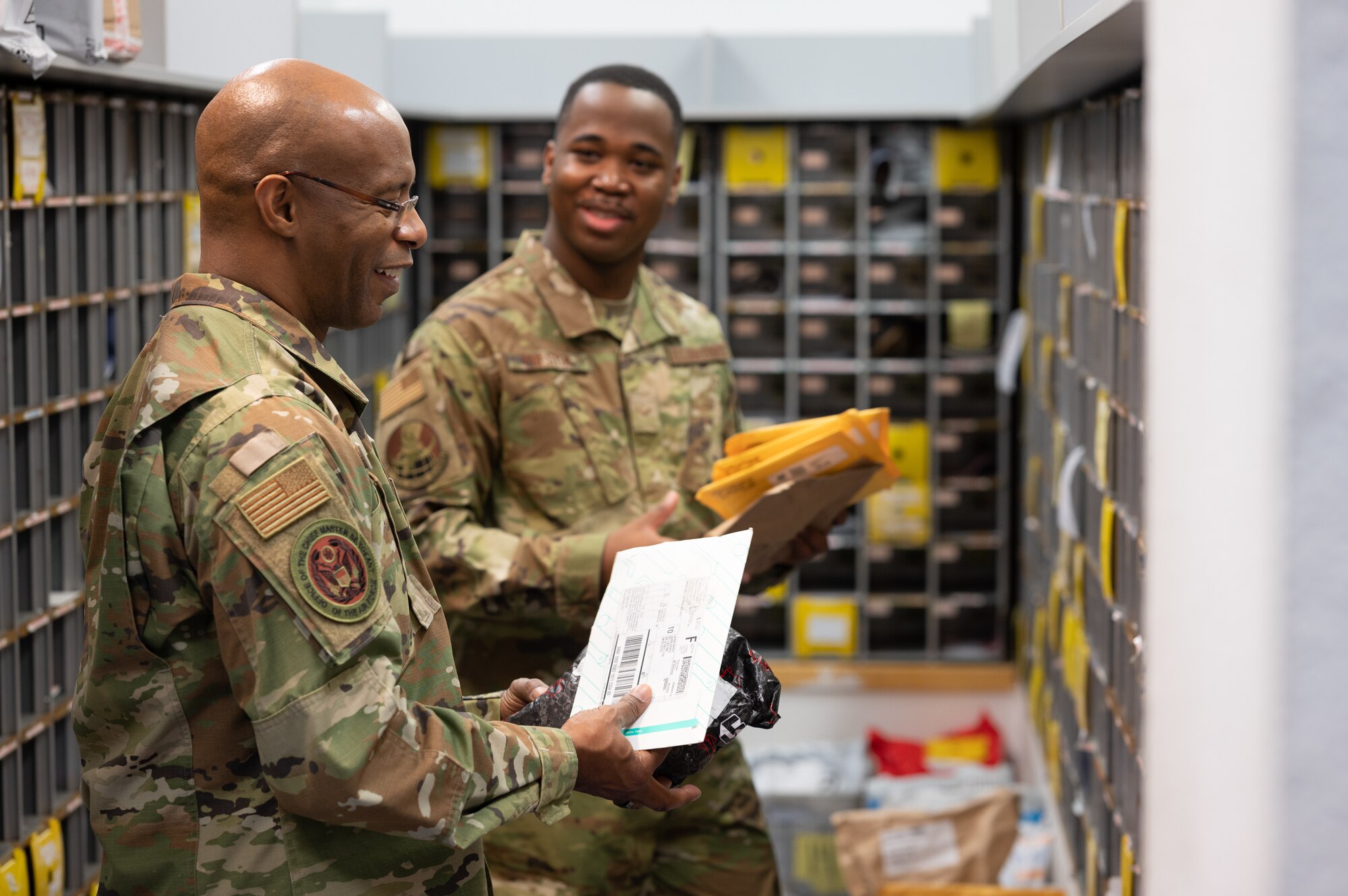 Two Airmen sorting mail.