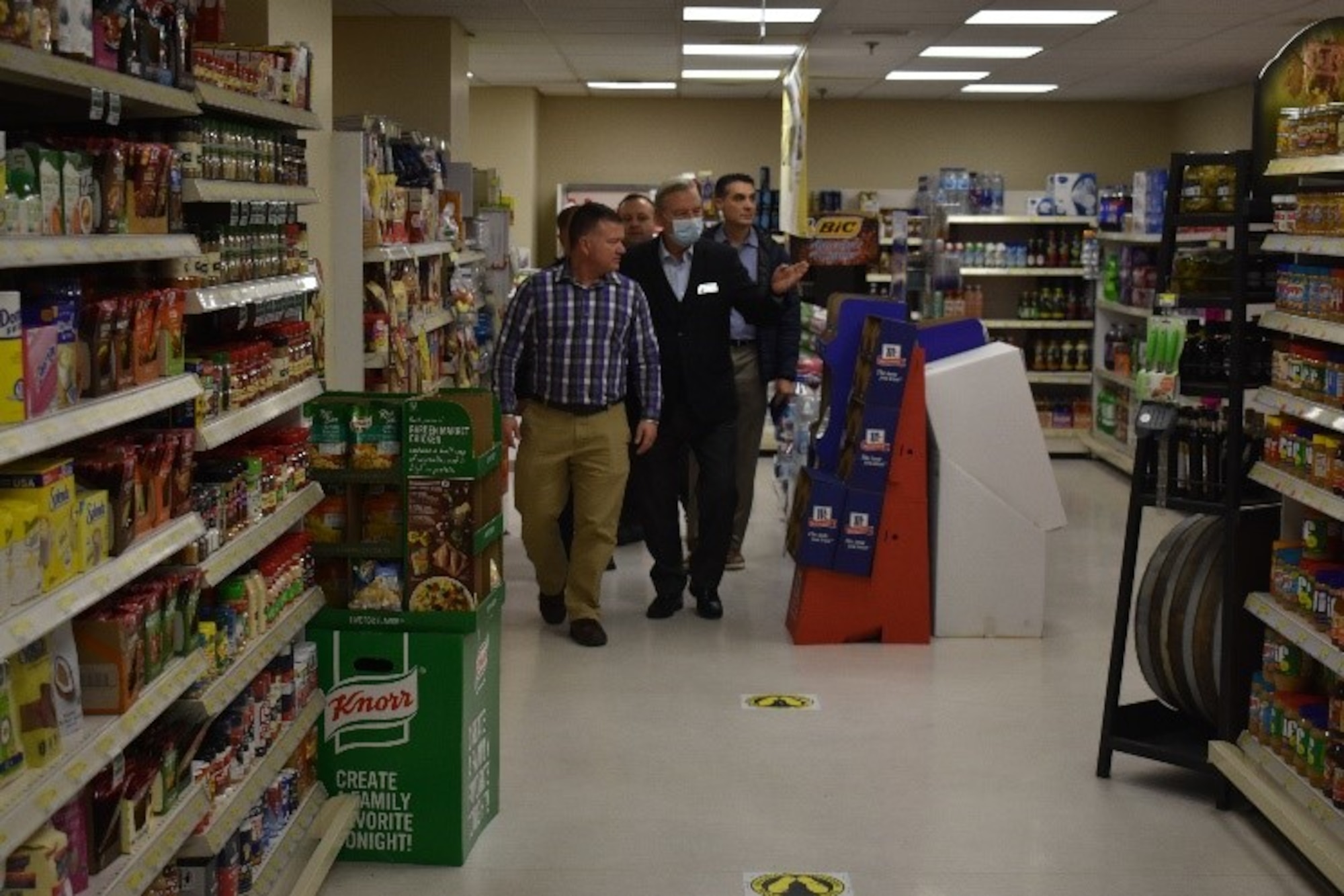 group of people walking in a grocery store