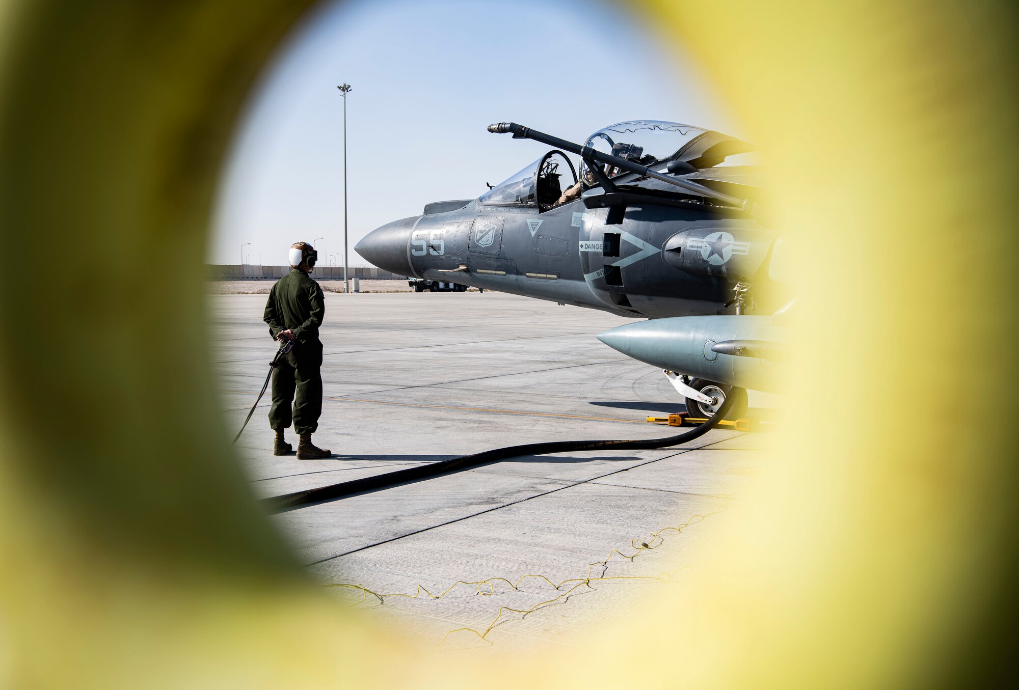 Marine watches as a fighter jet is refueled.