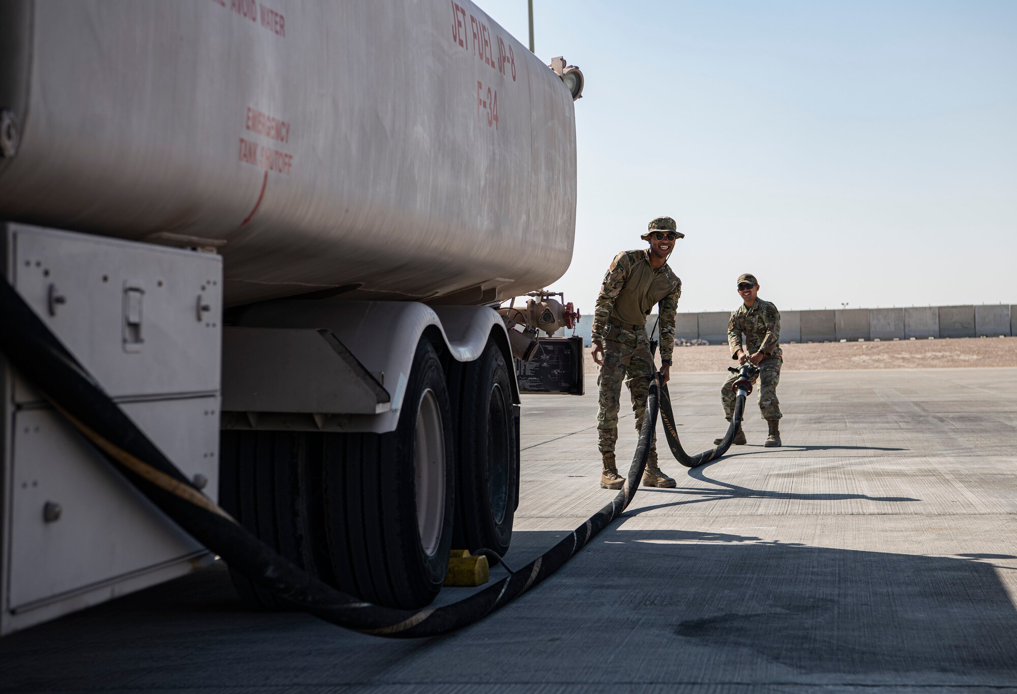 Airmen prep fuel hose to refuel an aircraft.