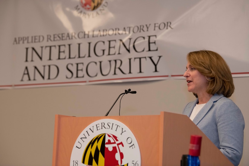 A woman speaks from behind  a lectern.