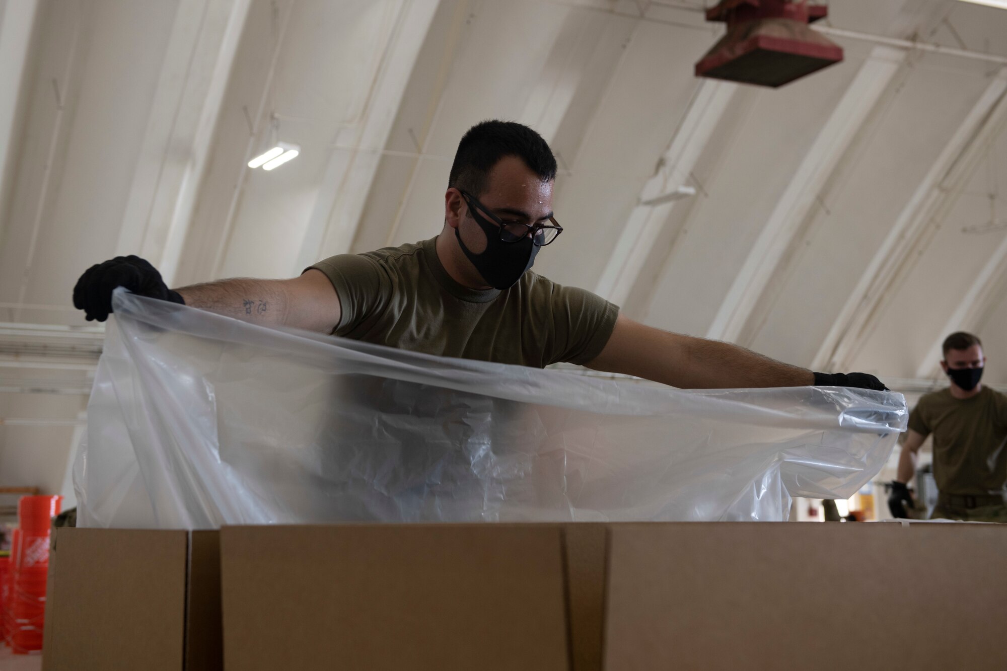 Airman 1st Class Madison Sinclair, 374th Logistics Readiness Squadron combat mobility flight technician, inserts a plastic liner into a practice bundle during the 70th Anniversary of Operation Christmas Drop at Andersen Air Force Base, Guam, Dec. 1, 2021. OCD is the Department of Defense’s longest running humanitarian aid and disaster relief training mission and provides relief to more than 50 islands throughout the Pacific. Operations such as OCD provide the U.S. and its partners the opportunity to enhance joint operational capabilities and maintain preparedness for real world emergencies. (U.S. Air Force photo by Tech. Sgt. Joshua Edwards)