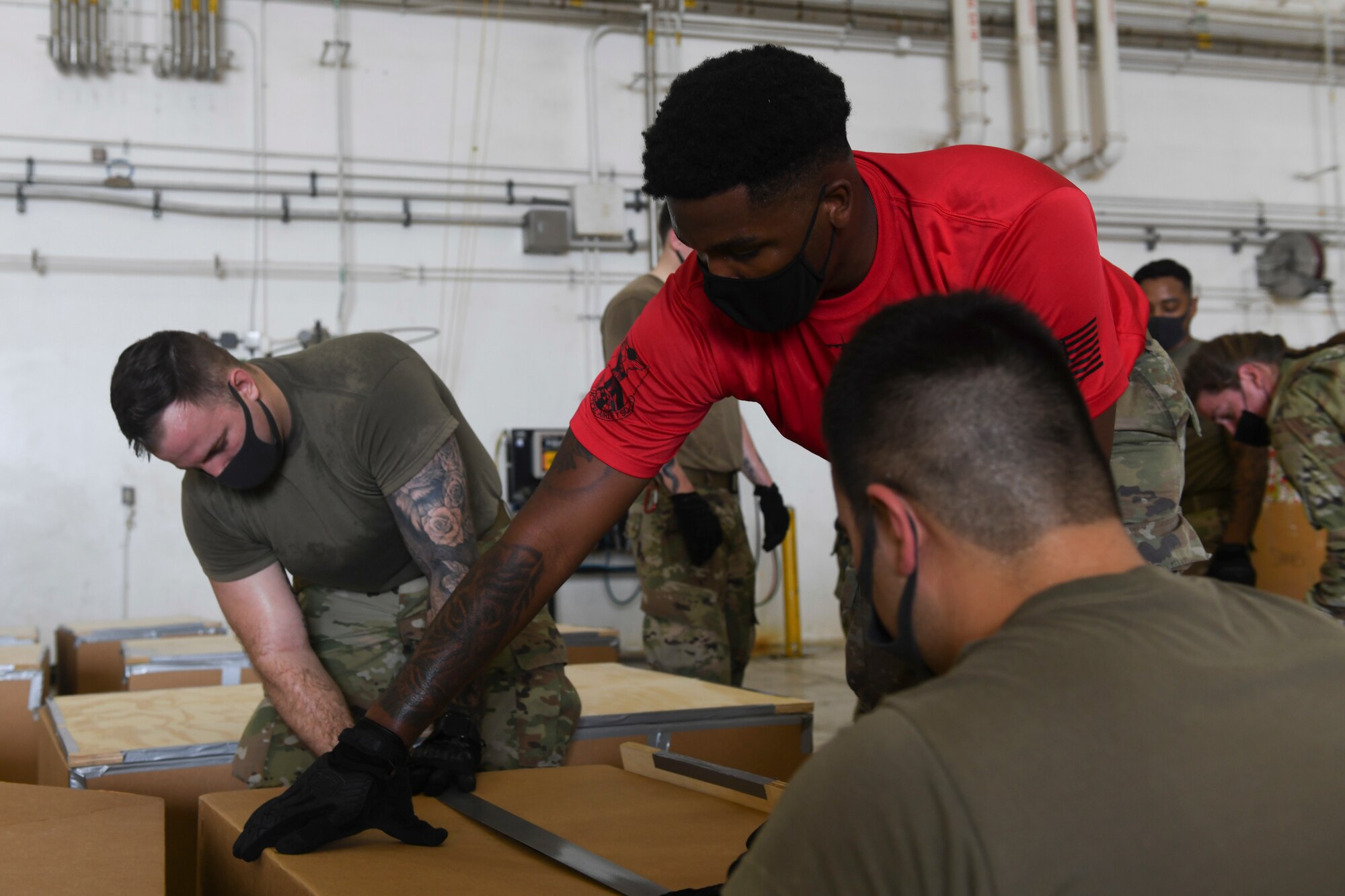 From left to right, Senior Airman Joshua Pollard, Airman 1st Class Jalen Riley and Airman 1st Class Madison Sinclair, 374th Logistics Readiness Squadron combat mobility technicians, tape a practice bundle during the 70th Anniversary of Operation Christmas Drop at Andersen Air Force Base, Guam, Dec. 1, 2021. OCD is the Department of Defense’s longest running humanitarian aid and disaster relief training mission and provides relief to more than 50 islands throughout the Pacific. Operations such as OCD provide the U.S. and its partners the opportunity to enhance joint operational capabilities and maintain preparedness for real world emergencies. (U.S. Air Force photo by Tech. Sgt. Joshua Edwards)