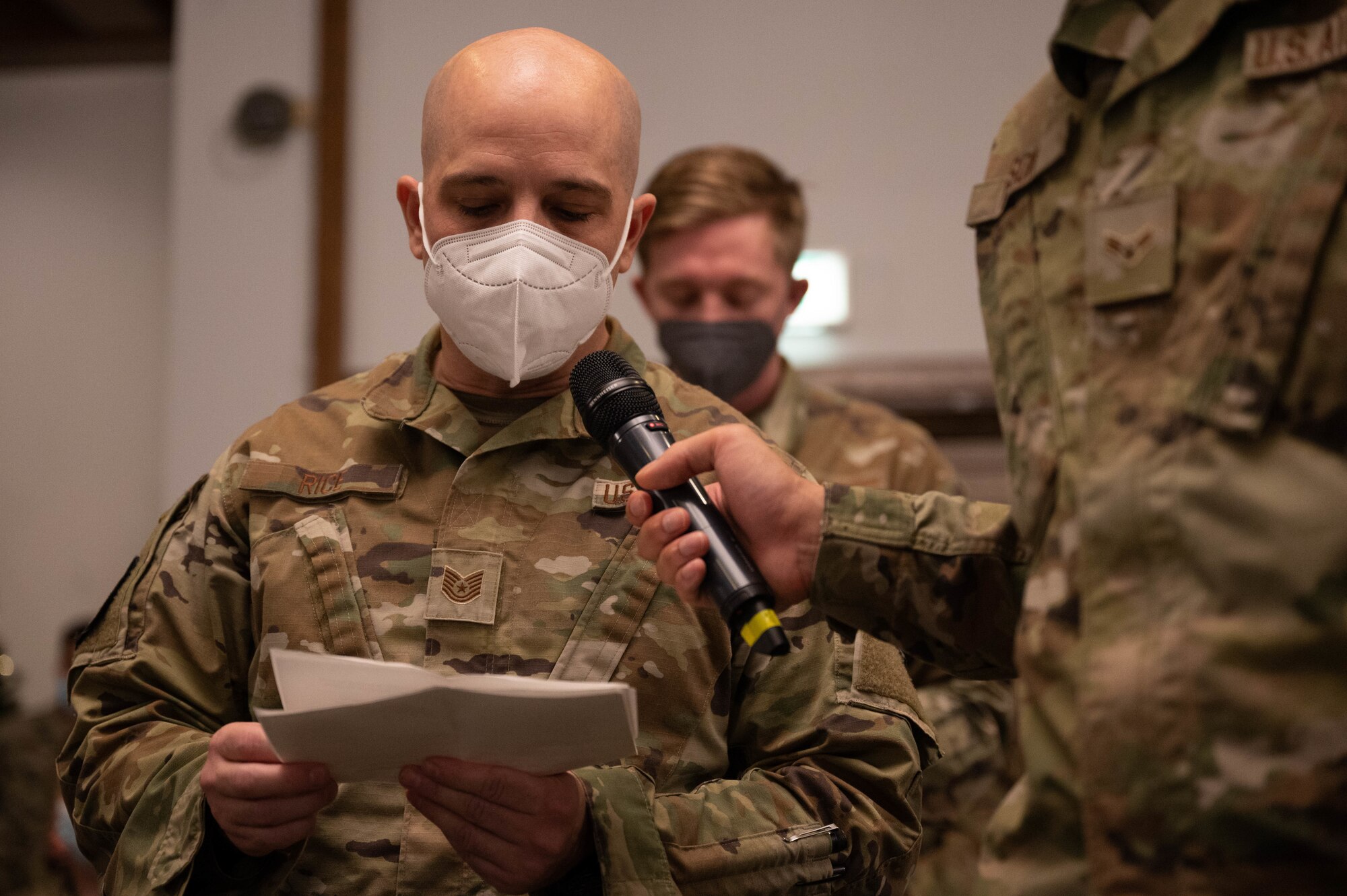 A military member speaking into a microphone.