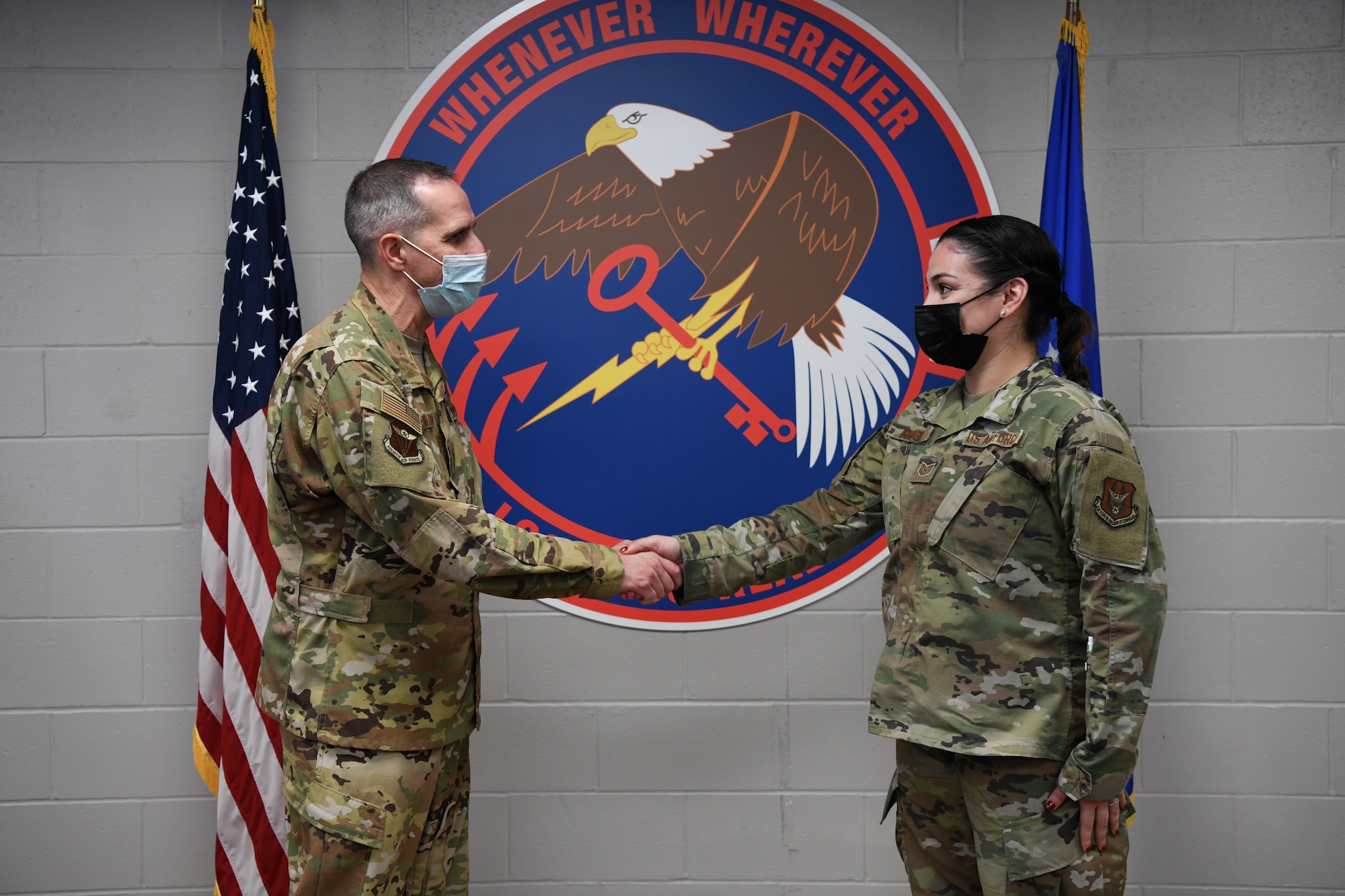 Maj. Gen. Jeffrey T. Pennington, 4th Air Force commander, presents a coin to Tech. Sgt. Roselys Baugh, 445th Force Support Squadron force management NCO in charge, Nov. 6, 2021.The general visited with Airmen across the various squadrons and watched various training events both days. He recognized five Reserve Citizen Airmen selected by the units as being outstanding performers.