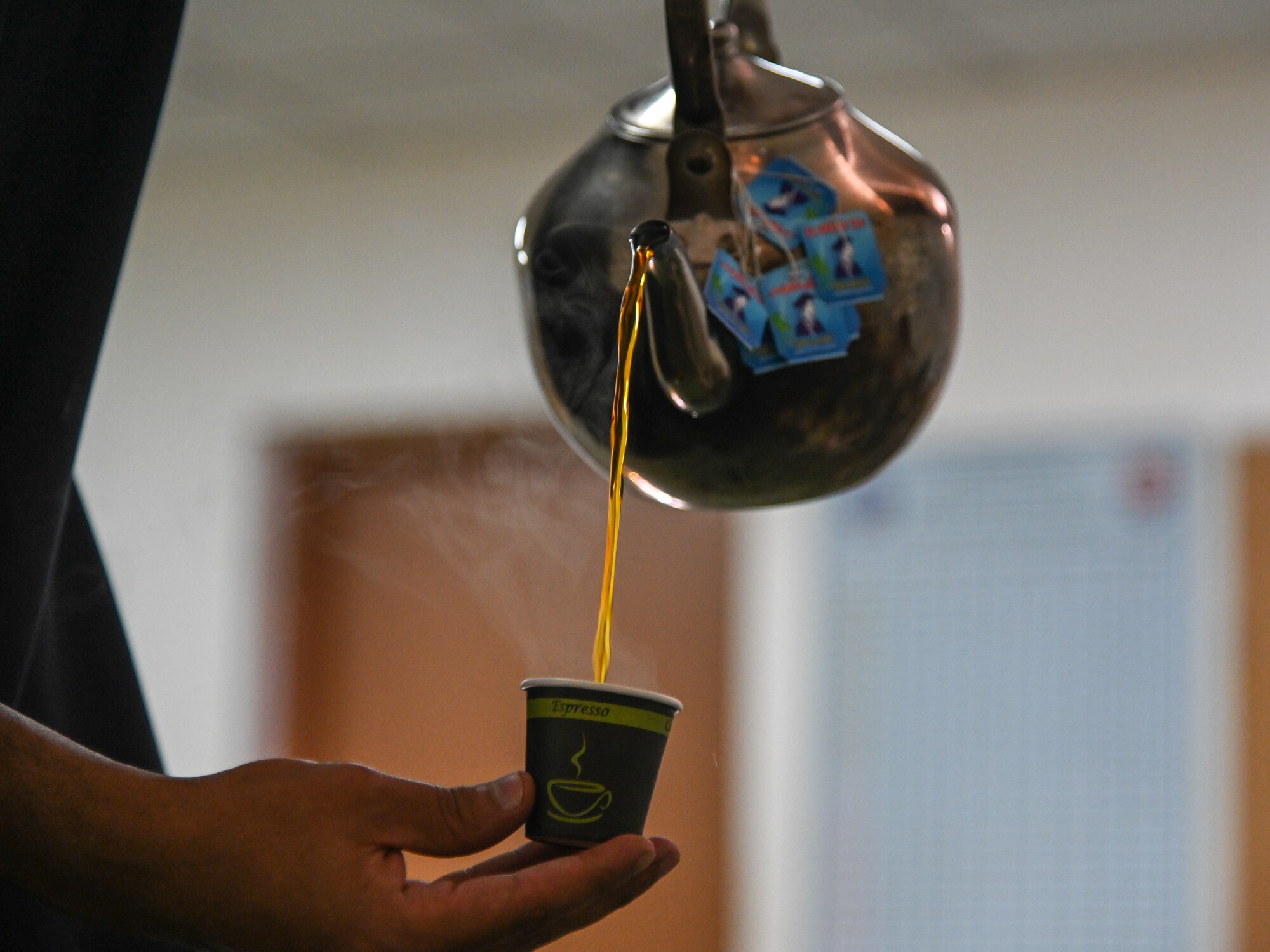 A service member from the Royal Saudi Air Force pours tea for Airmen from the 378th Expeditionary Civil Engineer Squadron fire department during an integrated training at Prince Sultan Air Base, Kingdom of Saudi Arabia, Nov. 24, 2021. The act of sharing tea is a staple of hospitality in Saudi culture and the tea is always poured and served by the youngest member in the room as a symbol of respect. (U.S. Air Force photo by Staff Sgt. Christina Graves)