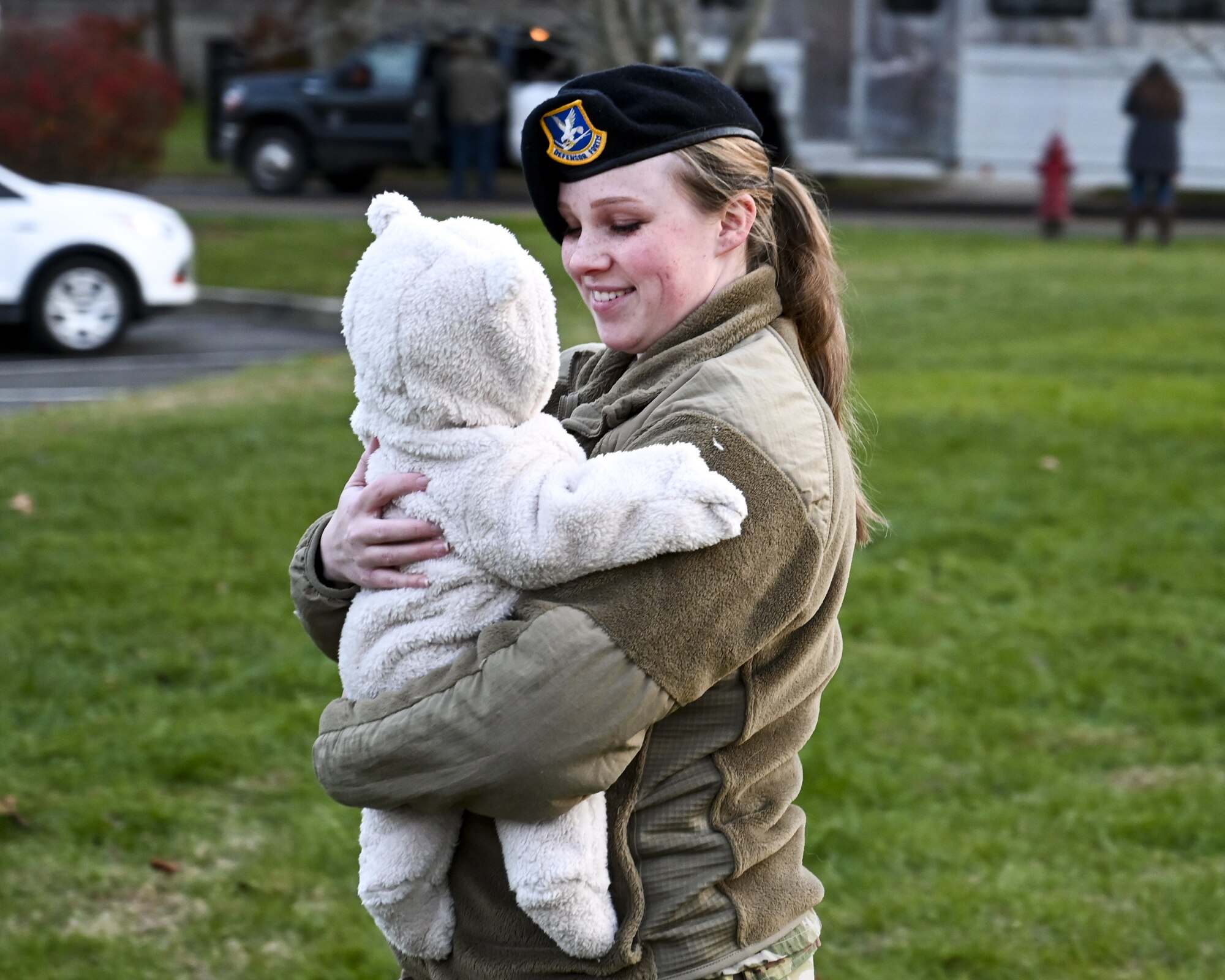 An 87th Security Force Squadron Airman holds her child during the Christmas Tree Lighting Ceremony held at Wurman Hall on Army Support Activity Dix, N.J., Dec 1, 2021. The annual tradition attended by leadership and JB MDL families offered horse-drawn carriage rides, hot chocolate, cookies, funnel cake, pretzels, kettle corn and a special visit from the North Pole. (U.S. Air Force photo by SrA Matt Porter)