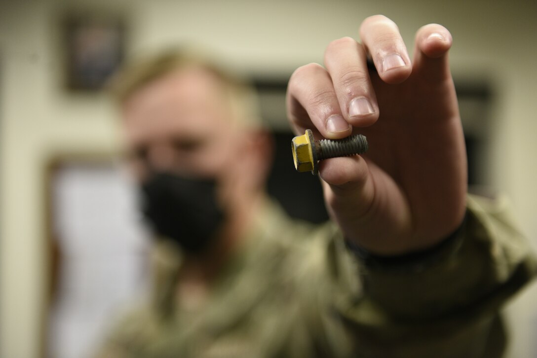 Airman 1st Class William Kozlowsky, 45th LRS Shift Lead, Displays a piece of Foreign Object Debris on August 23, 2021, at Patrick Space Force Base, Fla. FOD are objects that can damage aircrafts on the runway. (U.S. Space Force Photo by Airman 1st Class Samuel Becker)