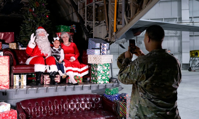 A father takes a photo of his daughter with Santa