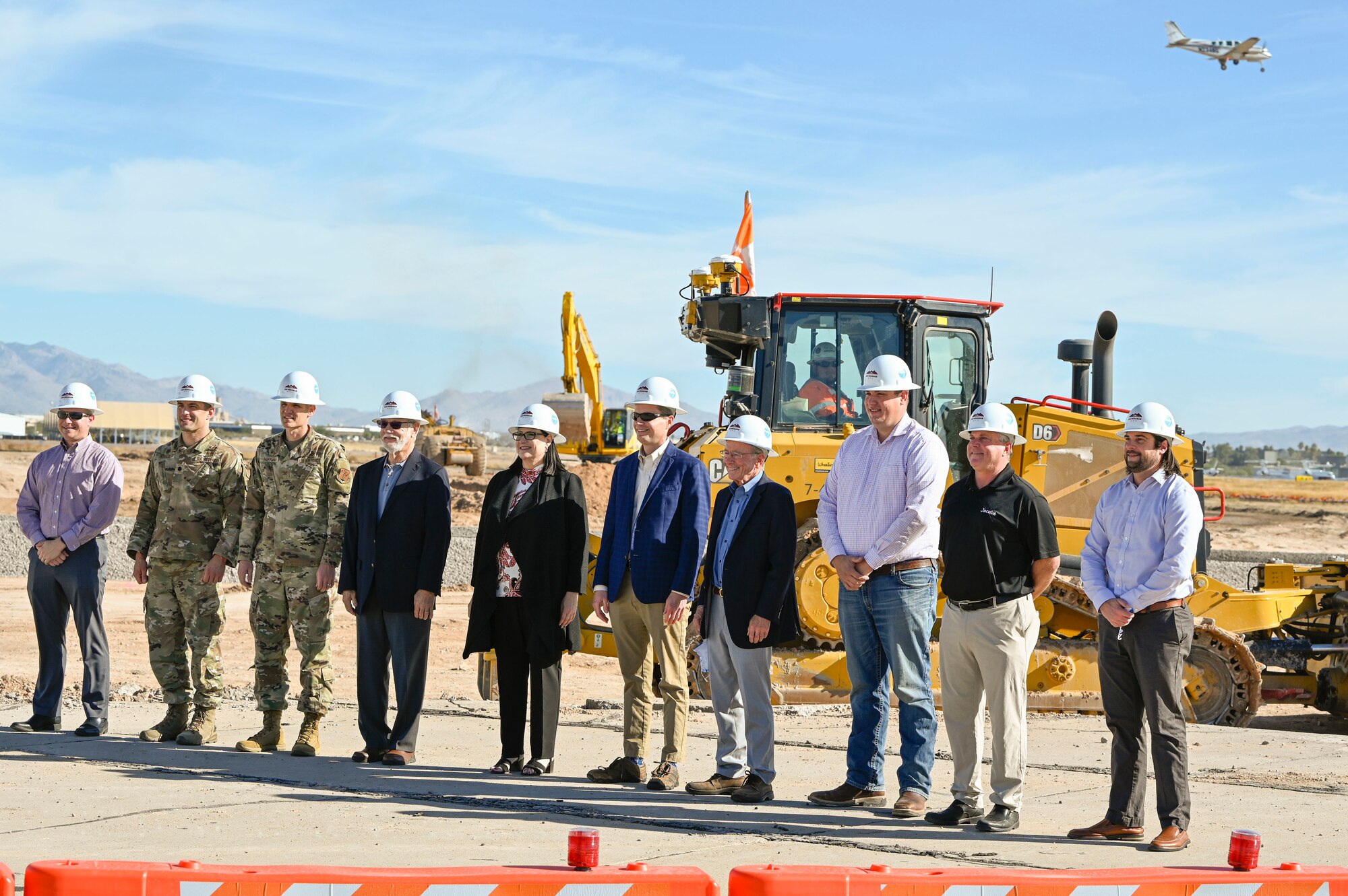U.S. Air Force Col. Greg Hoffman, commander, 162nd Mission Support Group Commander, 3rd from left and Lt. Col. Paul Boriack, 2nd from left, pose for a photo with members of the Tucson Airport Authority and construction crew leaders to commemorate the start of the End-Around Taxiway Project (referred to as DBB1). The end-around taxiway project is the first of three Design-Bid-Build (DBB) projects associated with the Airfield Safety Enhancement Program at the Tucson International Airport.