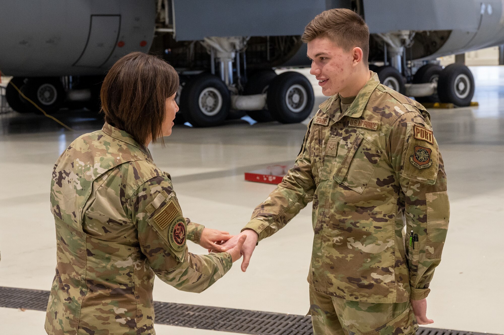 A military member giving another military member a coin.