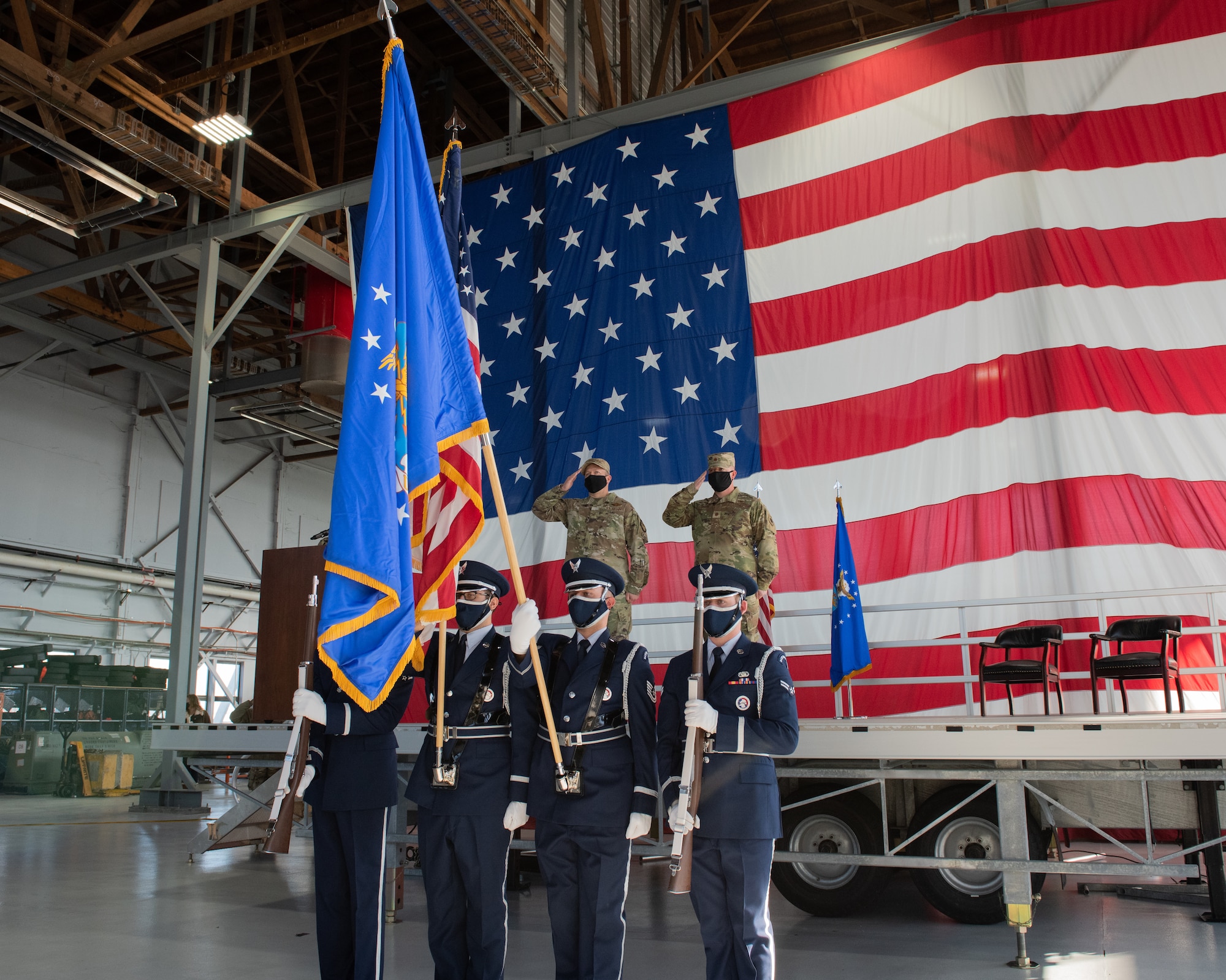 Col. DiVittorio and Maj. Griffin hold a salute behind the U.S. Air Force Color Guard during the playing of the United States National Anthem