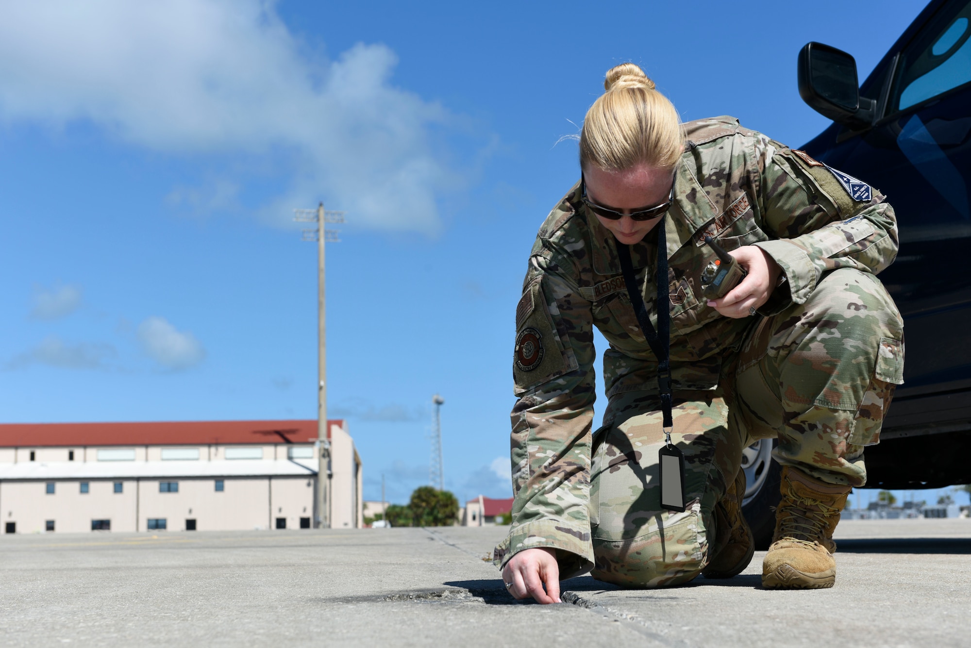 Tech. Sgt. Marlena Bledsoe, 45th LRS noncommissioned officer in charge of airfield management training, removes a piece of debris on the Flightline during an inspection of the airfield, on Oct. 12, 2021. Removing Foreign Object Debris is a vital part of securing the safety of the runway. Photo altered for security purposes (U.S. Space Force Photo by Airman 1st Class Samuel Becker)
