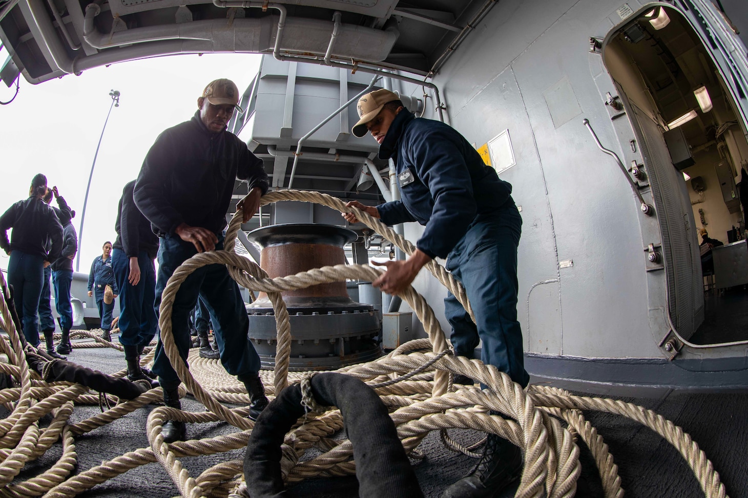 Boatswain's Mate Seaman Joshua Vergara, right, and Seaman Ibitayo Adewole prepare to fake line aboard amphibious assault ship USS Makin Island (LHD 8).