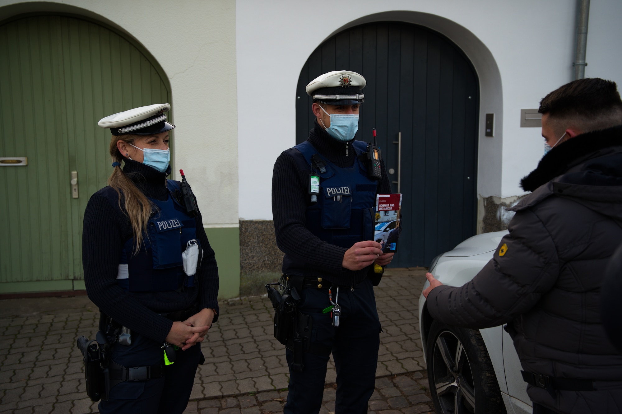The German Polizei distributes pamphlets to raise awareness of theft from motor vehicles during Operation Opportunity Leads to Theft at Kaiserslautern, Germany Nov. 24, 2021. In recent months, more cases of theft from motor vehicles have been reported to the German Polizei stations in Kaiserslautern. The Polizei found that the vehicles were often left unlocked. (U.S. Air Force photo by Senior Airman Branden Rae)