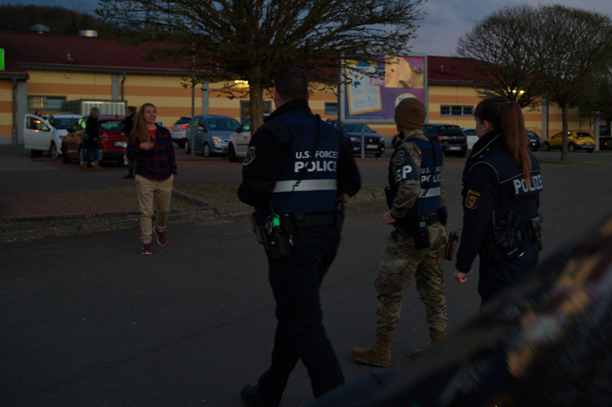 U.S. Force Police and German Polizei approach someone that left their car unlocked during Operation Opportunity Leads to Theft at Otterbach, Germany Nov. 24, 2021. The German Polizei stations in Kaiserslautern stated to residents to make sure that vehicles are locked even in personal driveways. Thieves prefer to check cars under the cover of darkness in the driveway. (U.S. Air Force photo by Senior Airman Branden Rae)