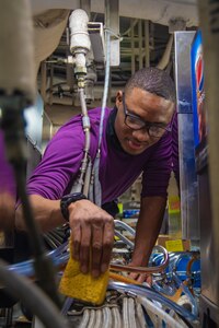 Aviation Boatswain's Mate (Fuel) Airman Jahquawn Clayton, from San Francisco, cleans vending machine hoses on the aft mess decks aboard the Nimitz-class aircraft carrier USS Harry S. Truman (CVN 75).