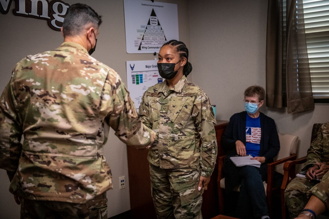 Col. Glenn Collins, 932nd Airlift Wing commander presents Staff Sgt. Margie Murphy, a 932nd Medical Squadron health services management technician, a wing challenge coin for sharing her Airman’s Story, February 5, 2021 at Scott Air Force Base, Illinois. (U.S. Air Force photo by Christopher Parr)