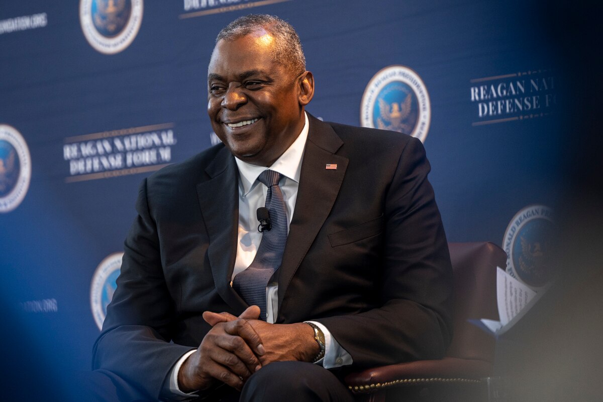 A man sits in a chair smiling.