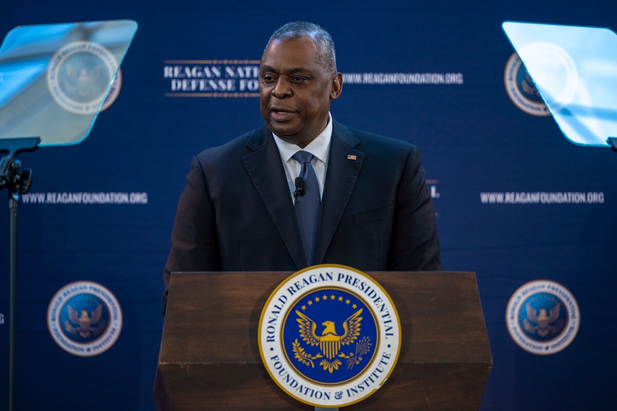 A man stands at a lectern speaking into a microphone.