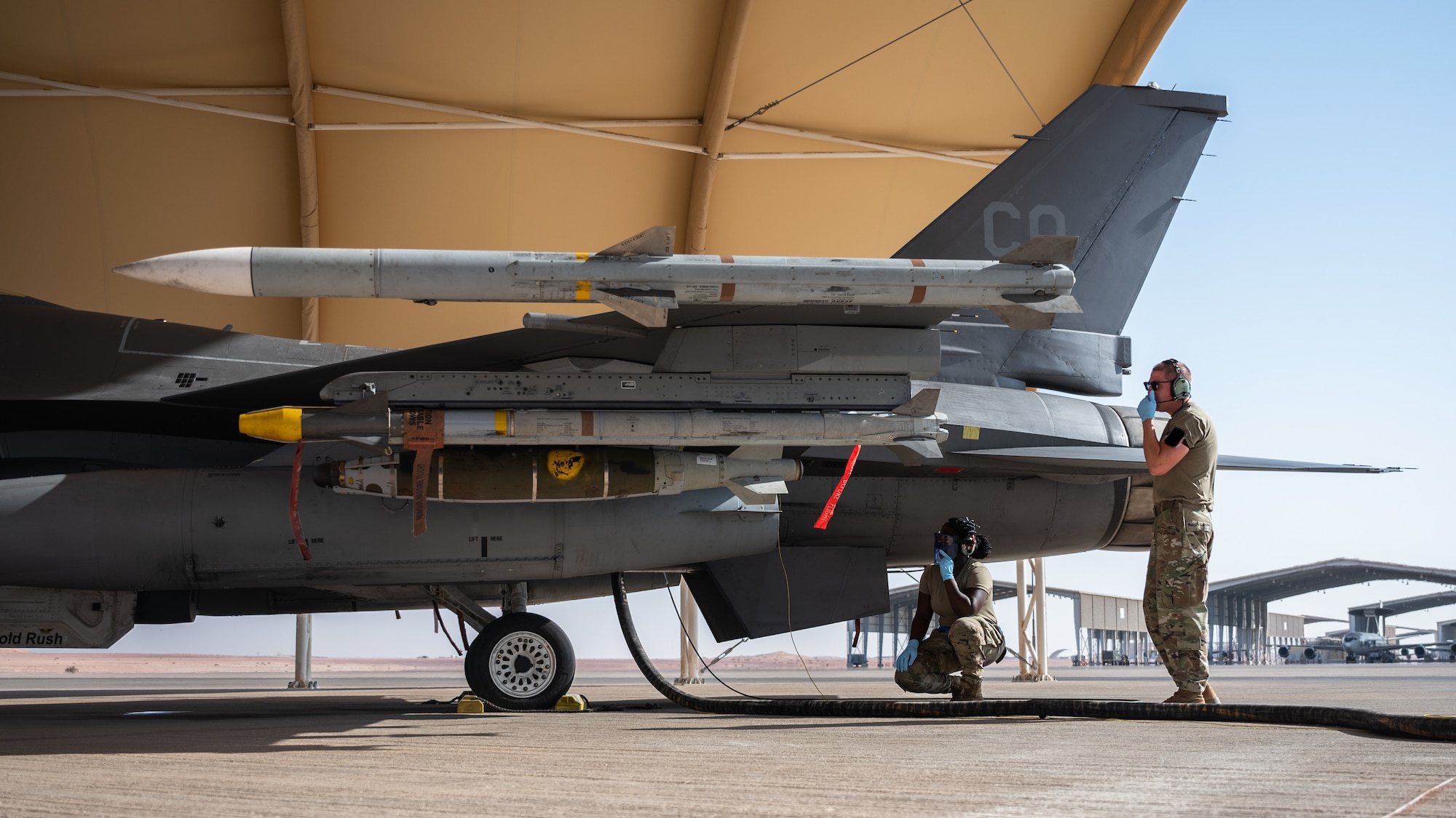 U.S. Air Force Tech. Sgt. Phyllis Sackey-Solomon, left, 379th Expeditionary Maintenance Squadron transient alert craftsman, and Master Sgt. Arik Armstrong, 378th EMXS quality assurance inspector, monitor the refueling of an F-16 Fighting Falcon at Prince Sultan Air Base, Kingdom of Saudi Arabia, Nov. 27, 2021. Sackey-Solomon was part of the group from Al Udeid Air Base, Qatar, who traveled to PSAB to become certified in refueling F-16s. (U.S. Air Force photo by Senior Airman Jacob B .Wrightsman)