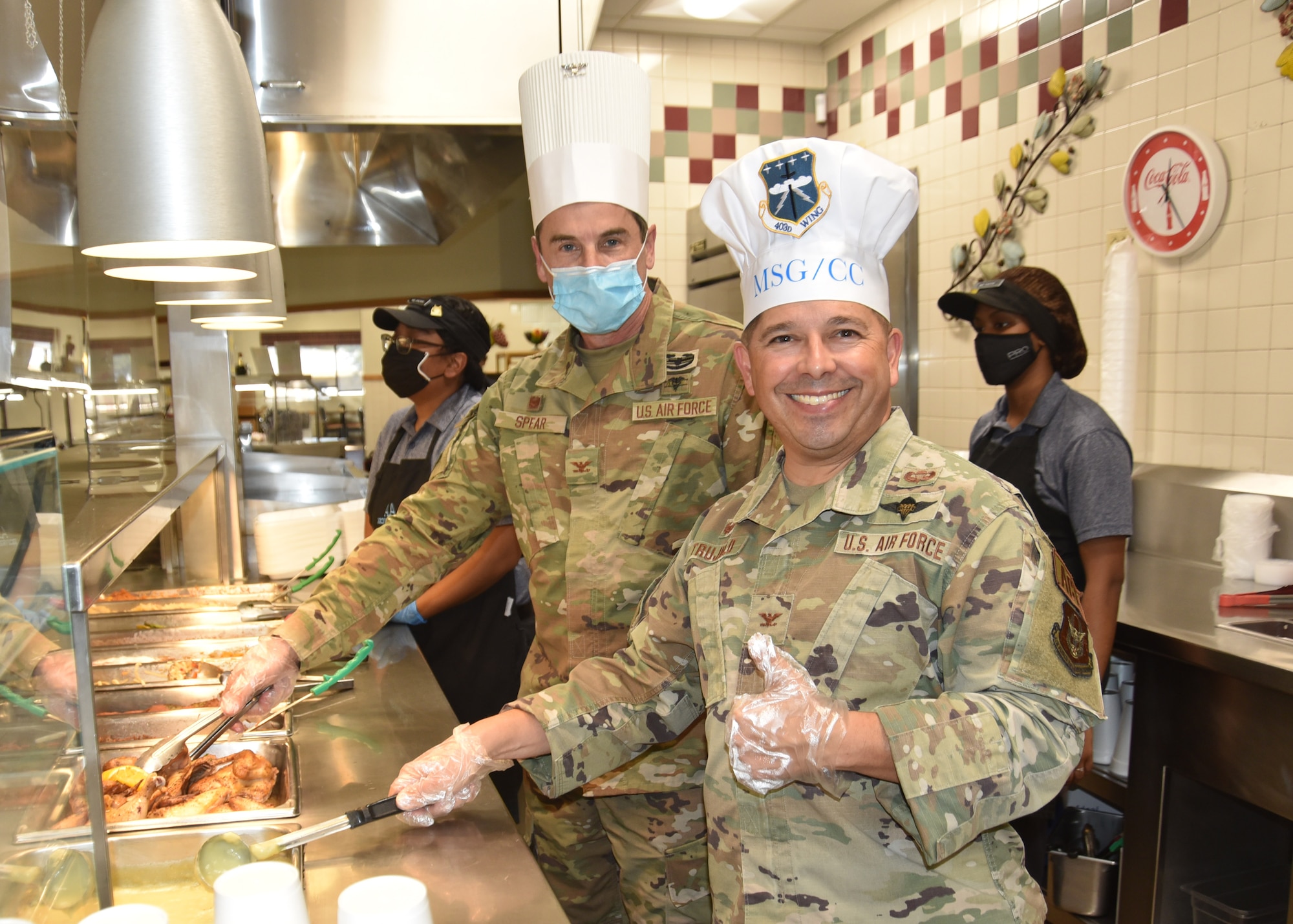 Col. Carl H. Spear Jr., (left)  and Col. Reginald G. Trujillo Jr. (right) stand together at the serving line.