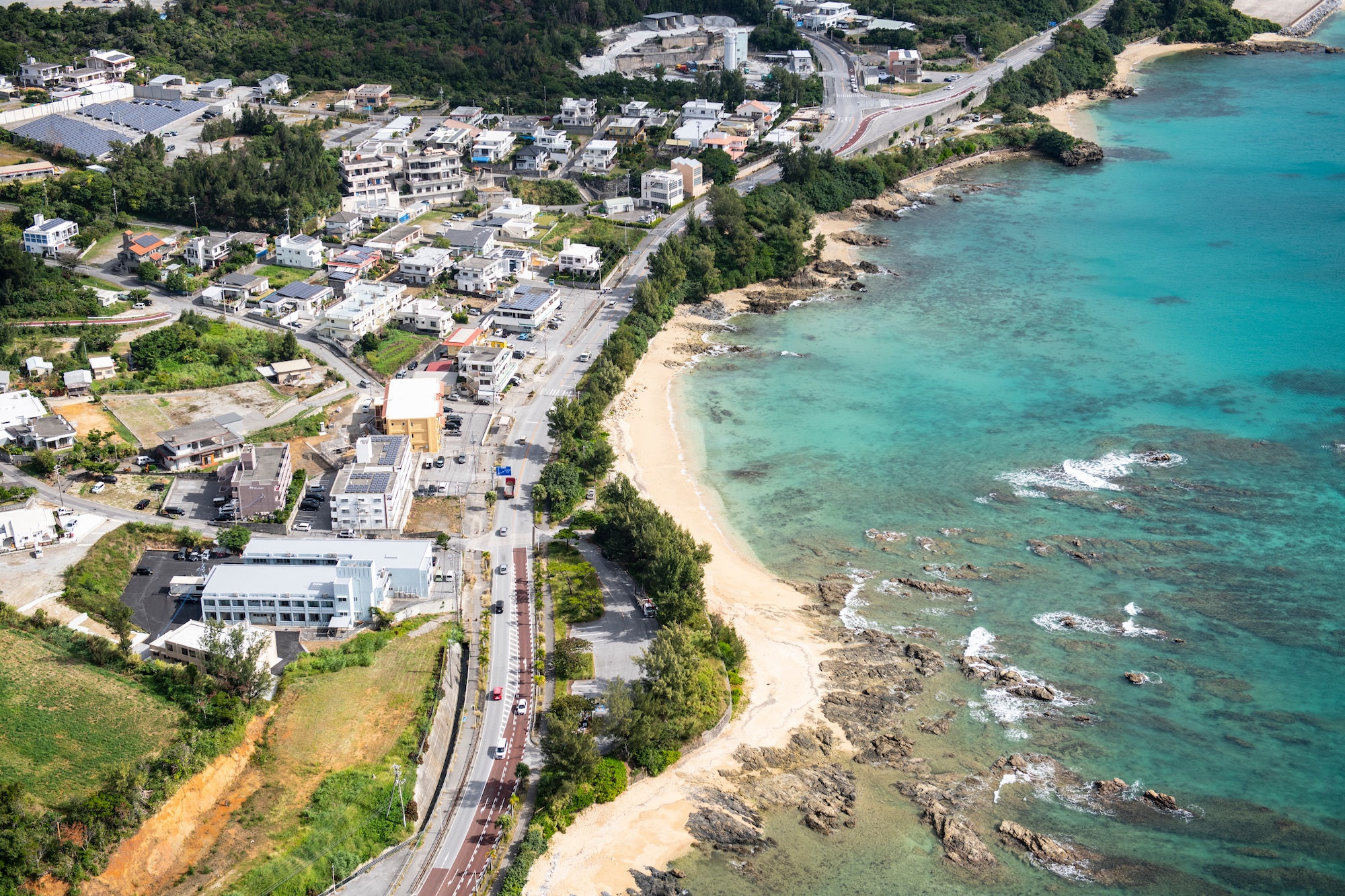 A view of the Okinawan coastline is visible from the window of an HH-60G Pave Hawk assigned to the 33rd Rescue Squadron as it travels to a training location over the Pacific Ocean, Dec. 1, 2021. The 33rd RQS provides a reliable combat search and rescue platform to aid in exercises and real-world operations in the Indo-Pacific region. (U.S. Air Force photo by Senior Airman Jessi Monte)