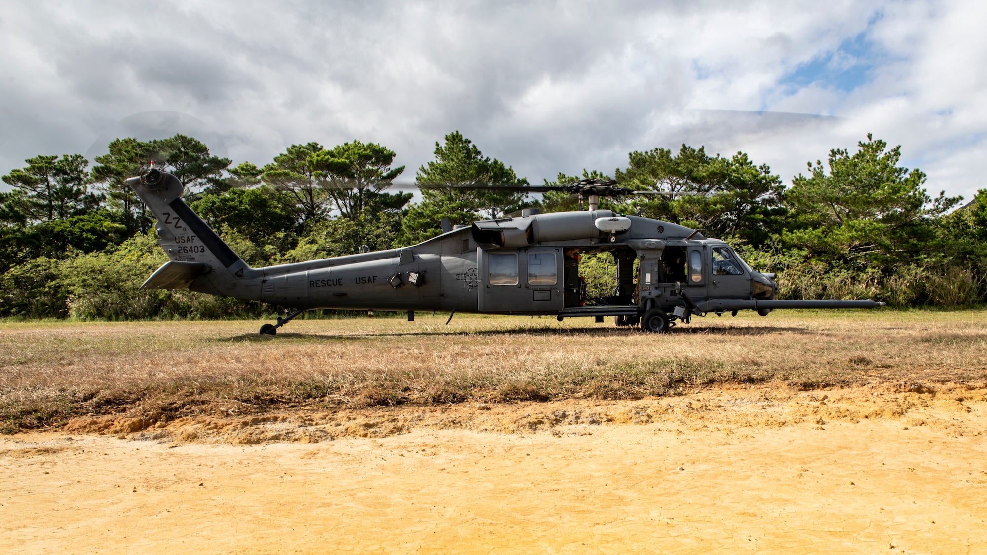 An HH-60G Pave Hawk assigned to the 33rd Rescue Squadron lands at an alternate landing zone during a training sortie out of Kadena Air Base, Japan, Dec. 1, 2021. Pave Hawks are equipped with folding rotor blades, improving air transportability and shipboard operations. (U.S. Air Force photo by Senior Airman Jessi Monte)