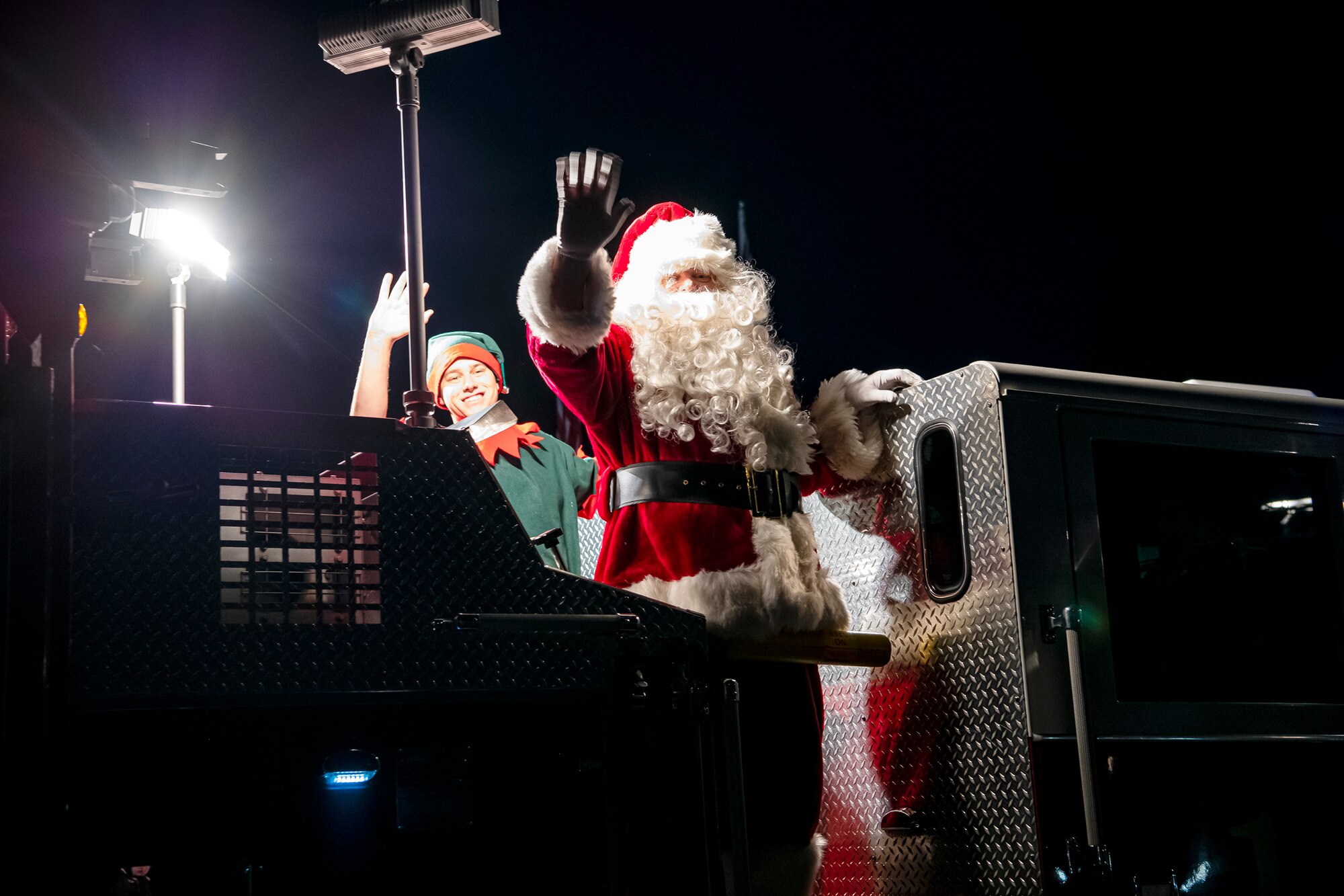 Santa and his elf wave to the crowd during a holiday tree lighting ceremony at RAF Croughton, England, Dec. 3, 2021. The 422d Air Base Group held a tree lighting ceremony and Christmas market that allowed Airmen and families to come together to celebrate the holiday season. (U.S. Air Force photo by Senior Airman Eugene Oliver)