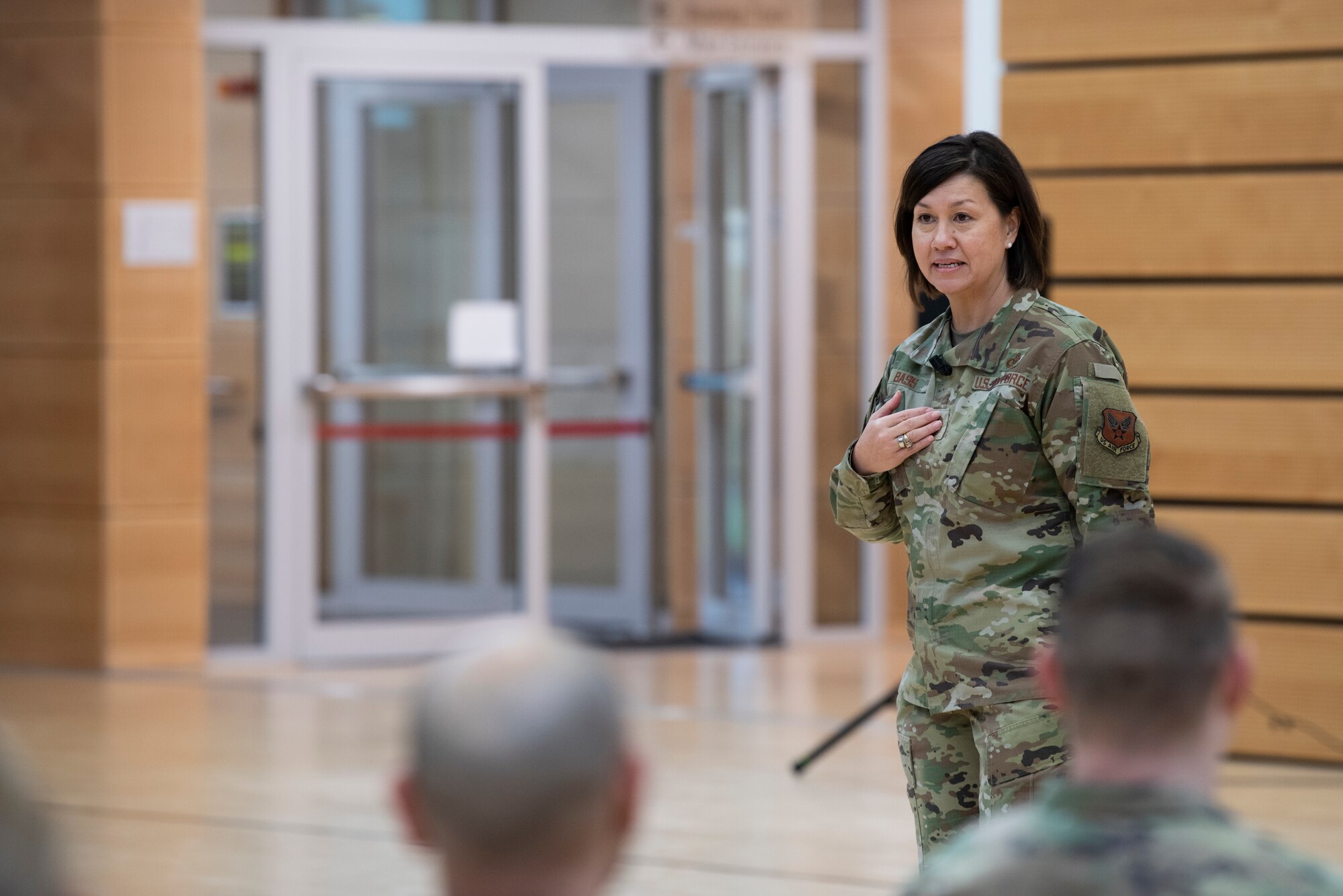 Chief Master Sgt. of the Air Force JoAnne S. Bass speaks in front of 52nd Fighter Wing Airmen, Dec. 2, 2021, on Spangdahlem Air Base, Germany. During her time at the 52nd Fighter Wing, Bass hosted an all-call, where she spoke about the strategic direction of the Air Force and provided an environment for Airmen to ask questions. (U.S. Air Force photo by Airman 1st Class Marcus Hardy-Bannerman)