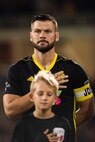 Soccer player standing on the field for the national anthem.