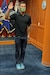 Man standing with is right arm raised in front of all military branch flags taking his Oath of Enlistment to join the United State Army.