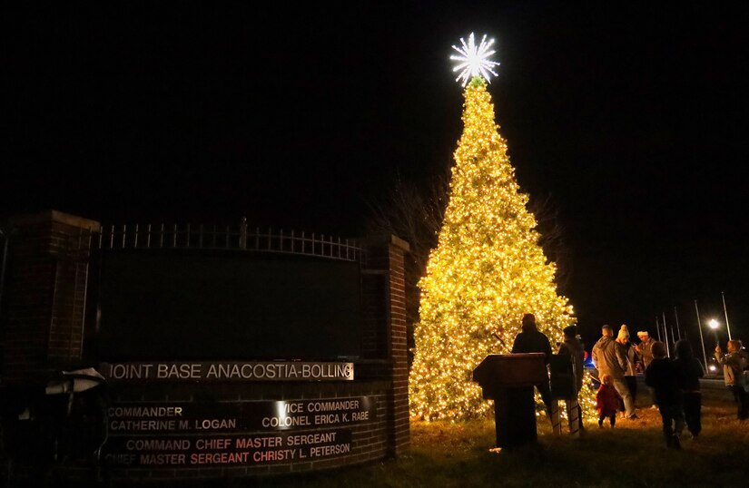 Families pose for pictures in front of the newly lit Christmas tree after the annual tree lighting ceremony on Joint Base Anacostia-Bolling, Washington D.C., Dec. 3, 2021. The tree-lighting ceremony marked the beginning of the holiday season at the installation. (U.S. Air Force photo by Brian Nestor)