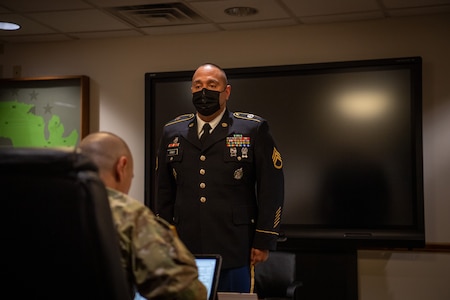 Soldier presenting himself in front of board members.