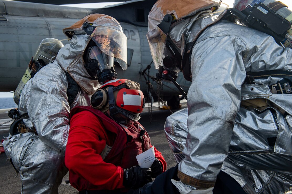 Sailors prepare to lift a simulated patient during a mass casualty drill on the flight deck of the Nimitz-class aircraft carrier USS Carl Vinson (CVN 70).