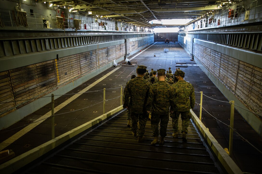 U.S. Marines with Fleet Marine Forces, Atlantic (FMFLANT), Marine Forces Command (MARFORCOM), Marine Forces Northern Command (MARFORNORTH) and the Intermediate Logistics Embarkation Course (ILEC) tour the USS Gunston Hall (LSD 44) at Naval Station Norfolk, Virginia, Nov. 16, 2021. The USS Gunston Hall is a United States Navy Whidbey Island-class dock landing ship designed to transport and launch loaded amphibious crafts with embarked personnel. Understanding the U.S. Navy’s capability to sustain operations globally contributes to the unit’s Force Design 2030 naval integration plan. (U.S. Marine Corps photo by Lance Cpl. Angel Alvarado)