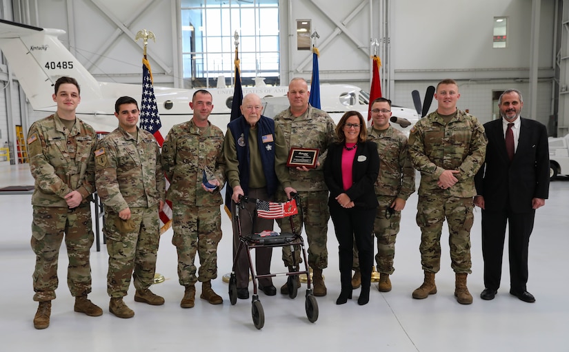 Karen L. Venis, Chief Executive Officer for Sayre Christian Village, resident Paul Frederick and Tim Veno, LeadingAge Kentucky President, pose for photo with six service members from the 63rd Theater Aviation Brigade after an award ceremony at the Army Aviation Support Facility hanger on Boone National Guard Center Dec. 2. The Soldiers are awarded the honors because of the assistance they provided during the pandemic. (US Army National Guard Photo by Mrs. Jesse Elbouab)