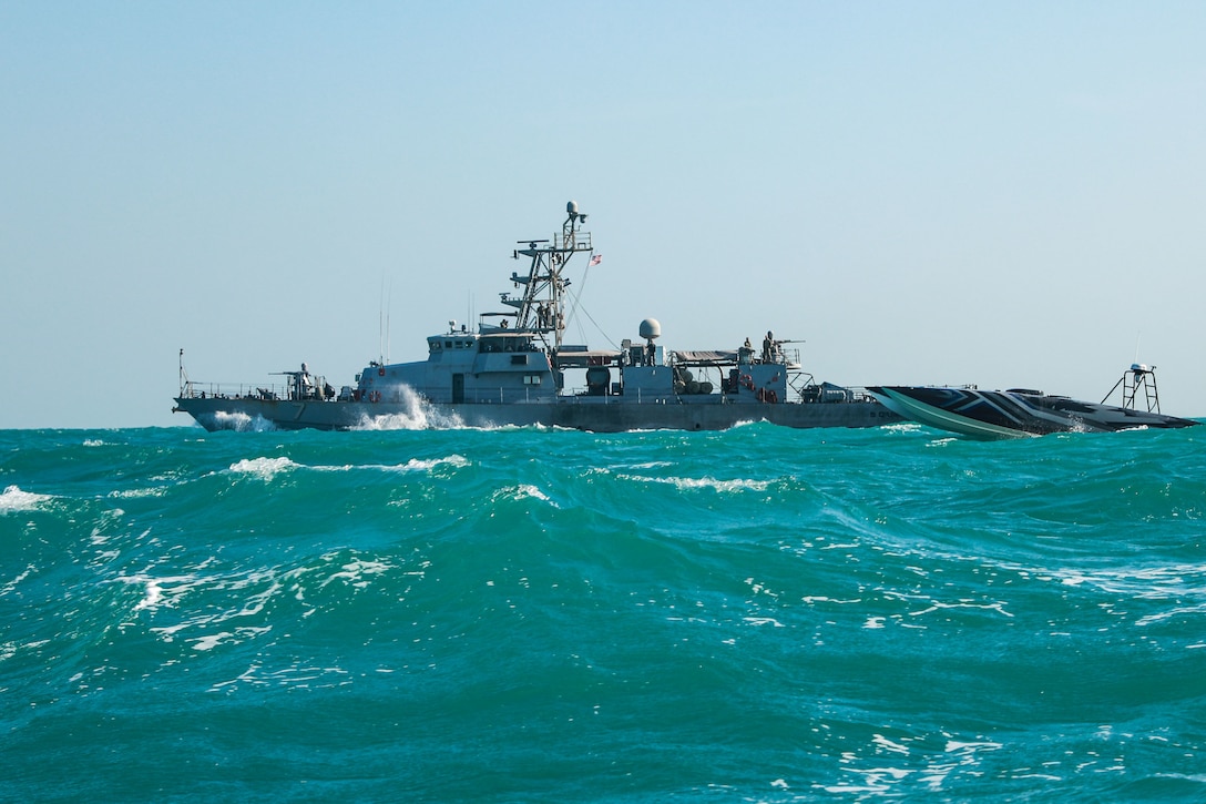 A MANTAS T-38 unmanned surface vessel operates alongside patrol coastal ship USS Squall (PC 7) in the Arabian Gulf, Dec. 4. Ongoing evaluations of new unmanned systems in U.S. 5th Fleet drives discovery, innovation, and integration into fleet operations. (U.S. Army photo by Sgt. David Resnick)
