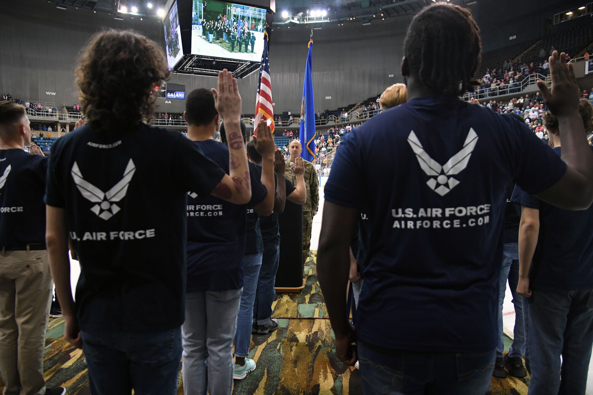 U.S. Air Force Col. William Hunter, 81st Training Wing commander, recites the oath of office to 16 Air Force delayed entry program recruits during the Biloxi Pro Hockey game inside the Mississippi Coast Coliseum at Biloxi, Mississippi, Dec. 2, 2021. The Keesler Air Force Base Honor Guard and Second Air Force leadership also participated in pre-game festivities. (U.S. Air Force photo by Kemberly Groue)