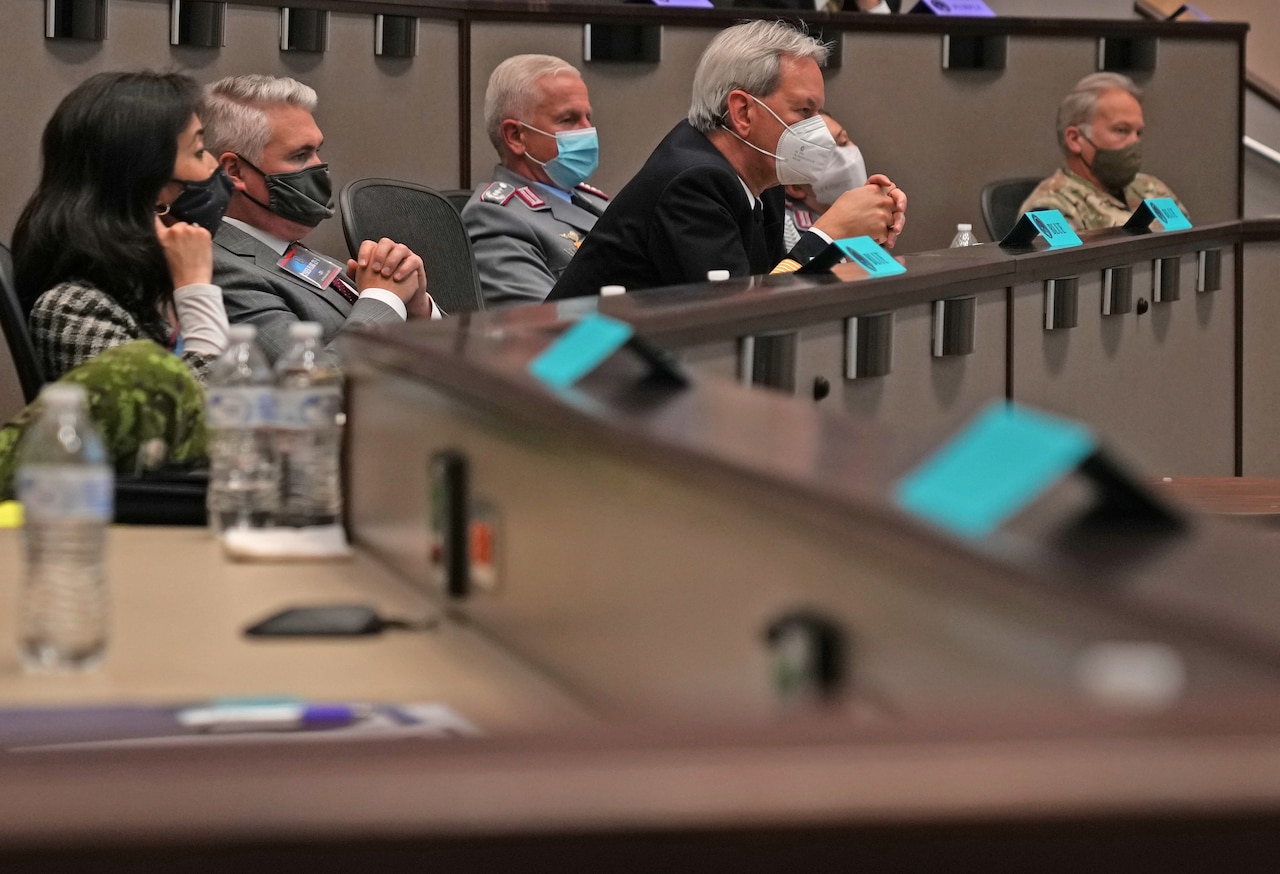 A group of people sit in a meeting room.