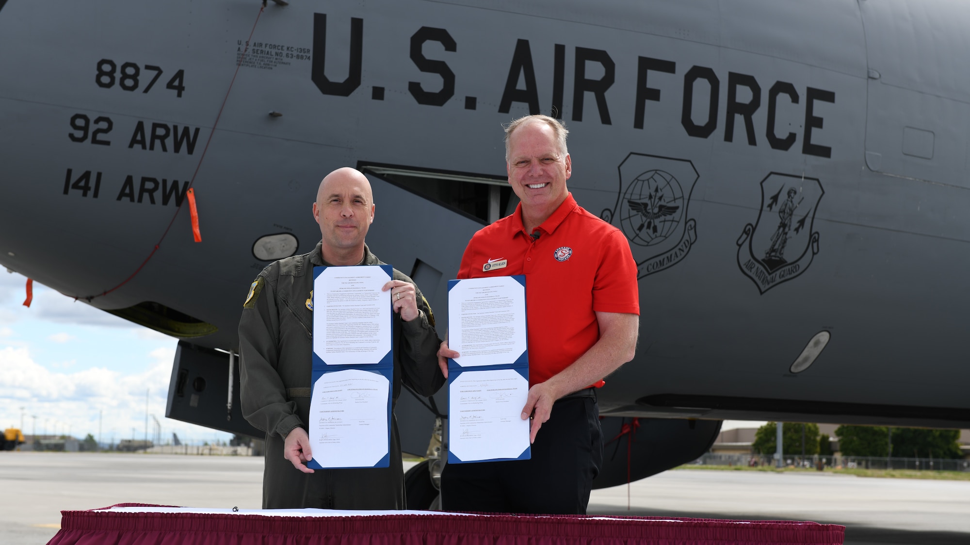 U.S. Air Force Col. Cassius Bentley, 92nd Air Refueling Wing commander, and Otto Klein, Spokane Indians Minor League Baseball team vice president, sign an agreement enacting Operation Fly Together at Fairchild Air Force Base, Washington, May 25, 2021. Fairchild Air Force Base's partnership with the Indians became known as Operation Fly Together and celebrates the KC-135 Stratotanker and the Airmen serving on the base, as well as the thousands of veterans from all branches of the Armed Forces who reside in the Spokane community. (U.S. Air Force photo by Senior Airman Breanne White)