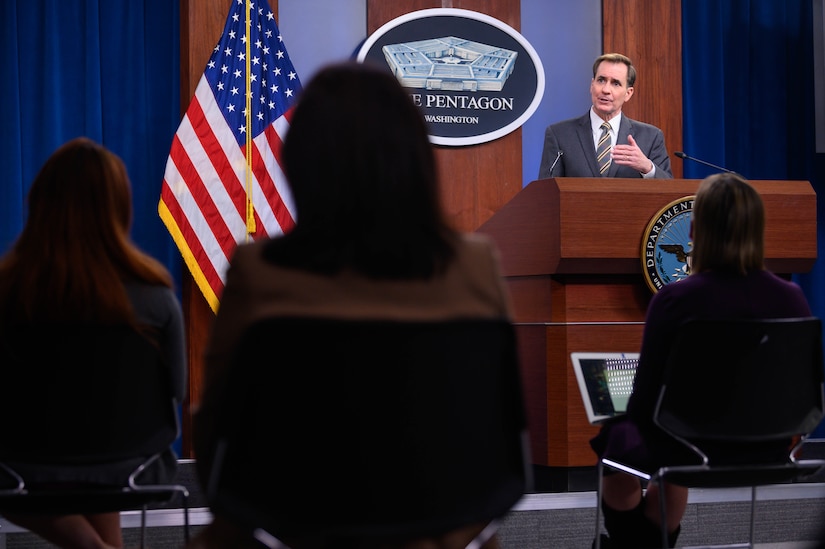 A man speaks from a lectern. The sign behind him indicates that he is at the Pentagon.