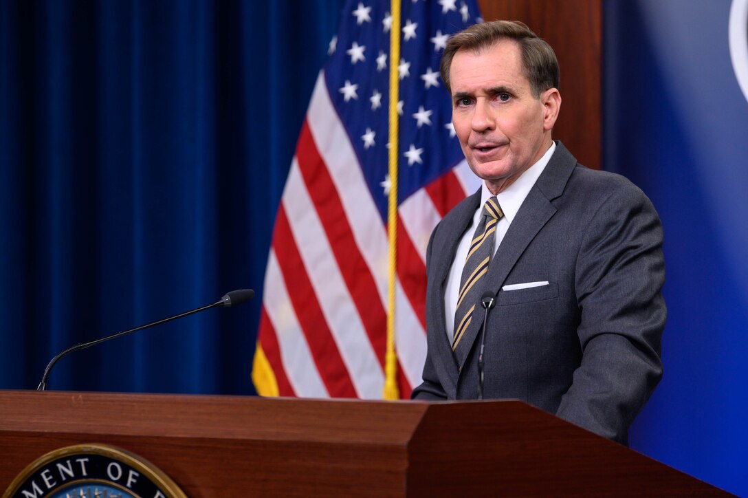 A man speaks to the press from a lectern.