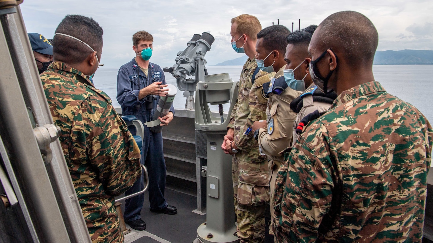 211206-N-PH222-1633 SAVU SEA (Dec. 6, 2021) Mineman 2nd Class Adam McFarland, from Boise, Idaho, conducts seamanship training with members of the Timor-Leste Defense Force from the bridge wing aboard to Independence-variant littoral combat ship USS Charleston (LCS 18), during Cooperation Afloat Readiness and Training (CARAT) exercise. In its 27th year, the CARAT series is comprised of multinational exercises, designed to enhance U.S. and partnered navies’ abilities to operate together in response to traditional and non-traditional maritime security challenges in the Indo-Pacific region. Charleston, part of Destroyer Squadron (DESRON) 7, is on a rotational deployment in the U.S. 7th Fleet area of operation to enhance interoperability with partners and serve as a ready-response force in support of a free and open Indo-Pacific region. (U.S. Navy photo by Mass Communication Specialist 2nd Class Ryan M. Breeden)